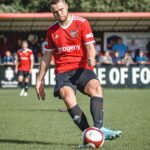 Male Sheffield FC player kicking ball