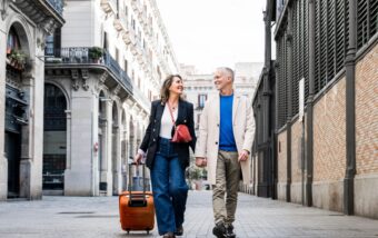 Affectionate,Mid,Adult,Tourist,Couple,Walking,Together,With,Luggage,In