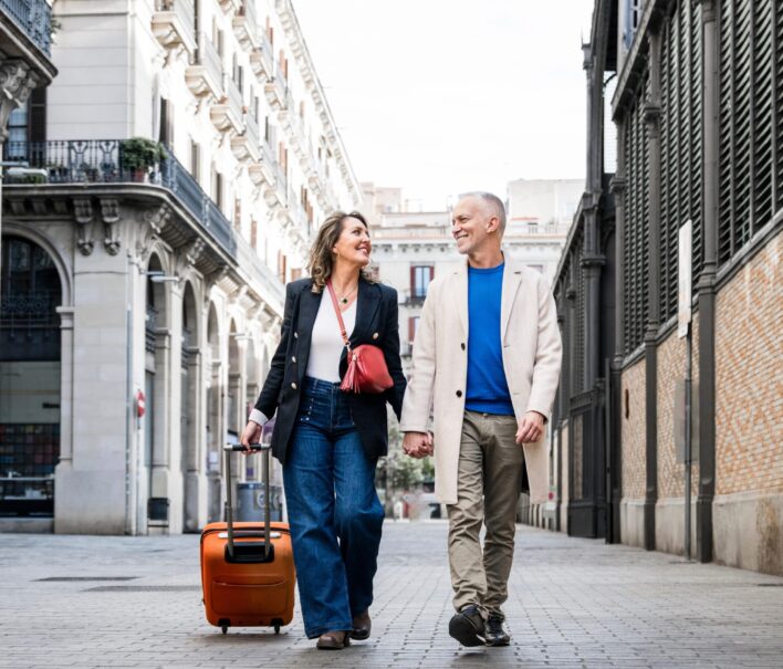 Affectionate,Mid,Adult,Tourist,Couple,Walking,Together,With,Luggage,In