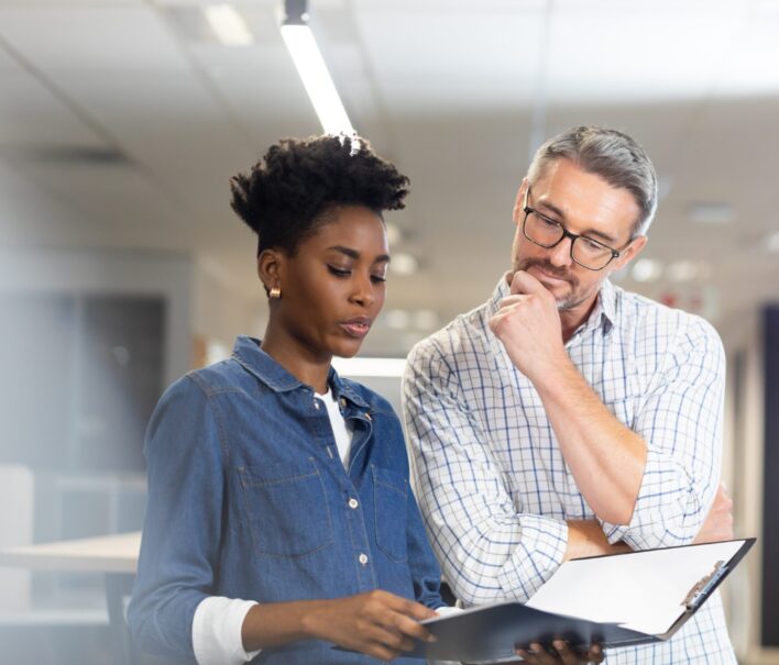 Confident,Biracial,Colleagues,Planning,Together,While,Discussing,Over,File,At