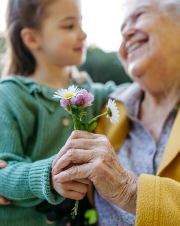 Granddaughter,Spending,Time,With,Elderly,Grandma,,Picking,Wildflowers.,Senior,Lady