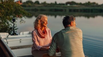 Senior,Couple,Sitting,On,A,Boat,,Savoring,The,Tranquil,Sunset
