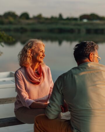 Senior,Couple,Sitting,On,A,Boat,,Savoring,The,Tranquil,Sunset