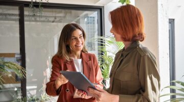 Two,Happy,Business,Women,Of,Young,And,Middle,Age,Talking