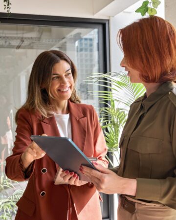 Two,Happy,Business,Women,Of,Young,And,Middle,Age,Talking